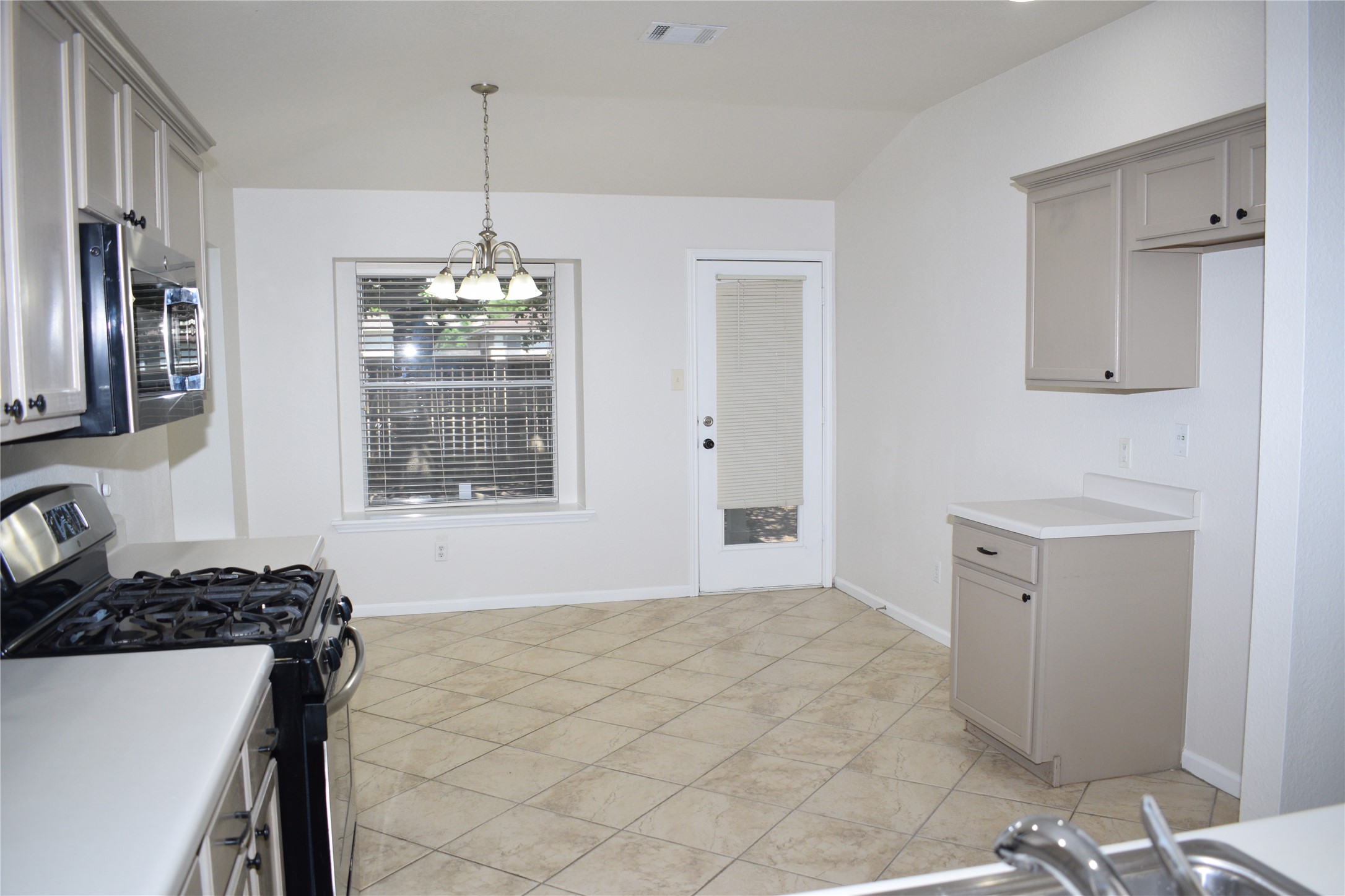 3209 Port Anne Way Leander, TX 78641 - Photo 5 of 30 Kitchen featuring tile flooring, white countertops, built-in stainless steel microwave, and gas range