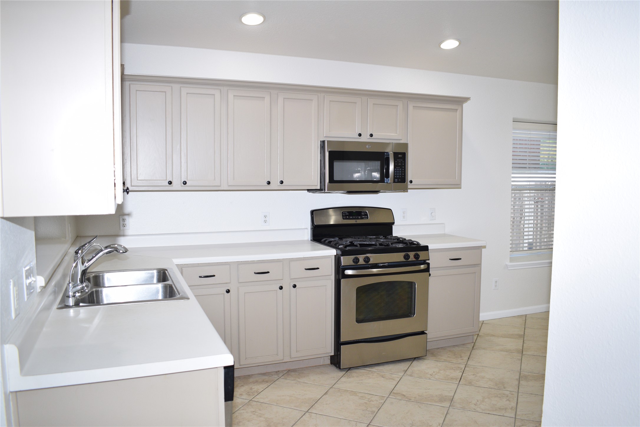 3209 Port Anne Way Leander, TX 78641 - Photo 6 of 30 Kitchen featuring light-toned cabinetry, stainless steel appliances, a double basin sink, and recessed lighting