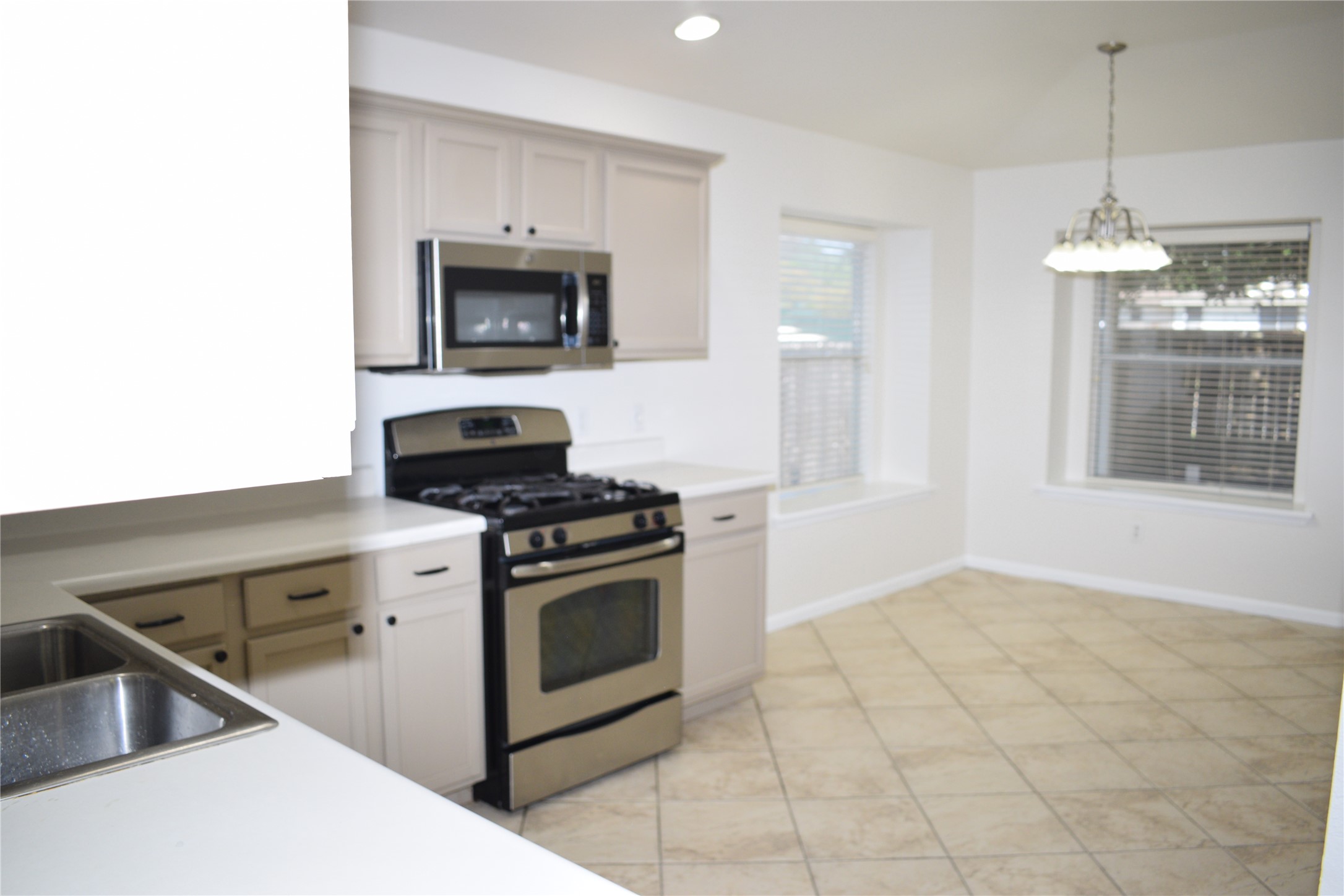 3209 Port Anne Way Leander, TX 78641 - Photo 7 of 30 Kitchen featuring stainless steel appliances, light-toned cabinetry, and a double basin sink