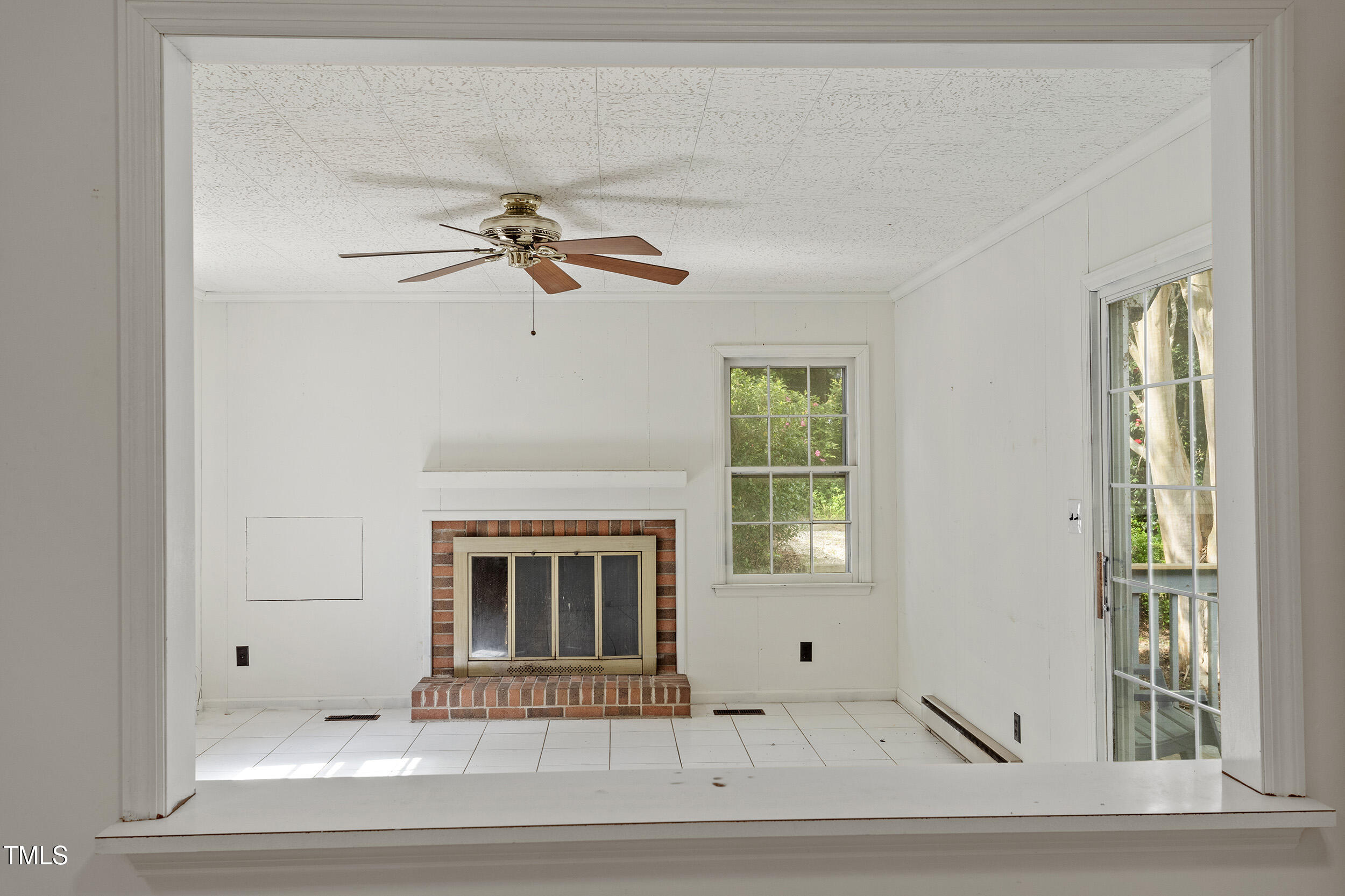 611 Beaver Dam Road Raleigh, NC 27607 - Photo 14 of 36 a living room with a fireplace furniture a ceiling fan and a window