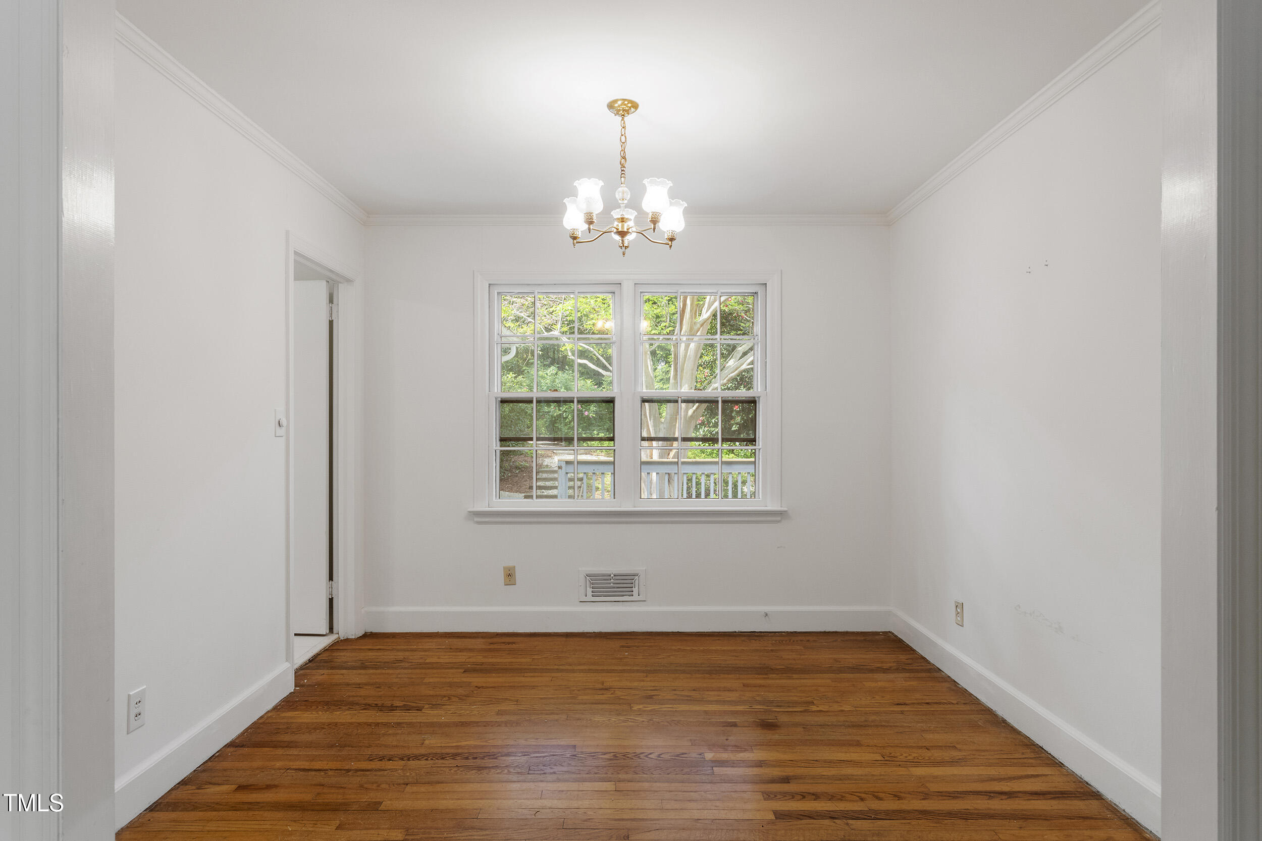 611 Beaver Dam Road Raleigh, NC 27607 - Photo 9 of 36 a view of an empty room with wooden floor and a window