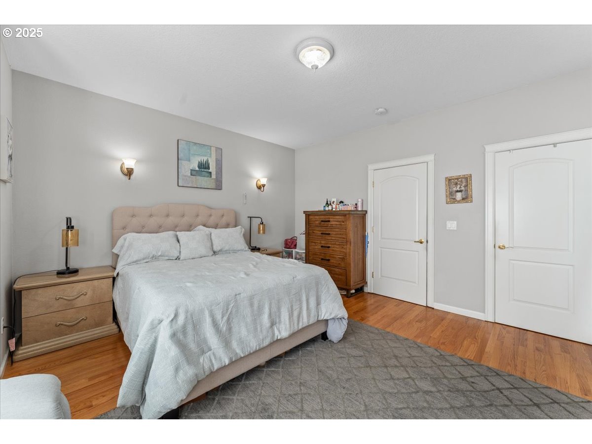 5122 Southeast Jenne Road Portland, OR 97236 - Photo 20 of 36 a bedroom with a bed and wooden floor