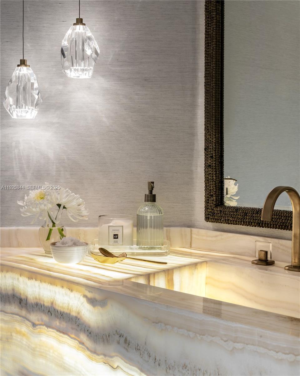 5757 Collins Avenue, Unit 1706 Miami Beach, FL 33140 - Photo 18 of 20 a bathroom with a sink and a mirror