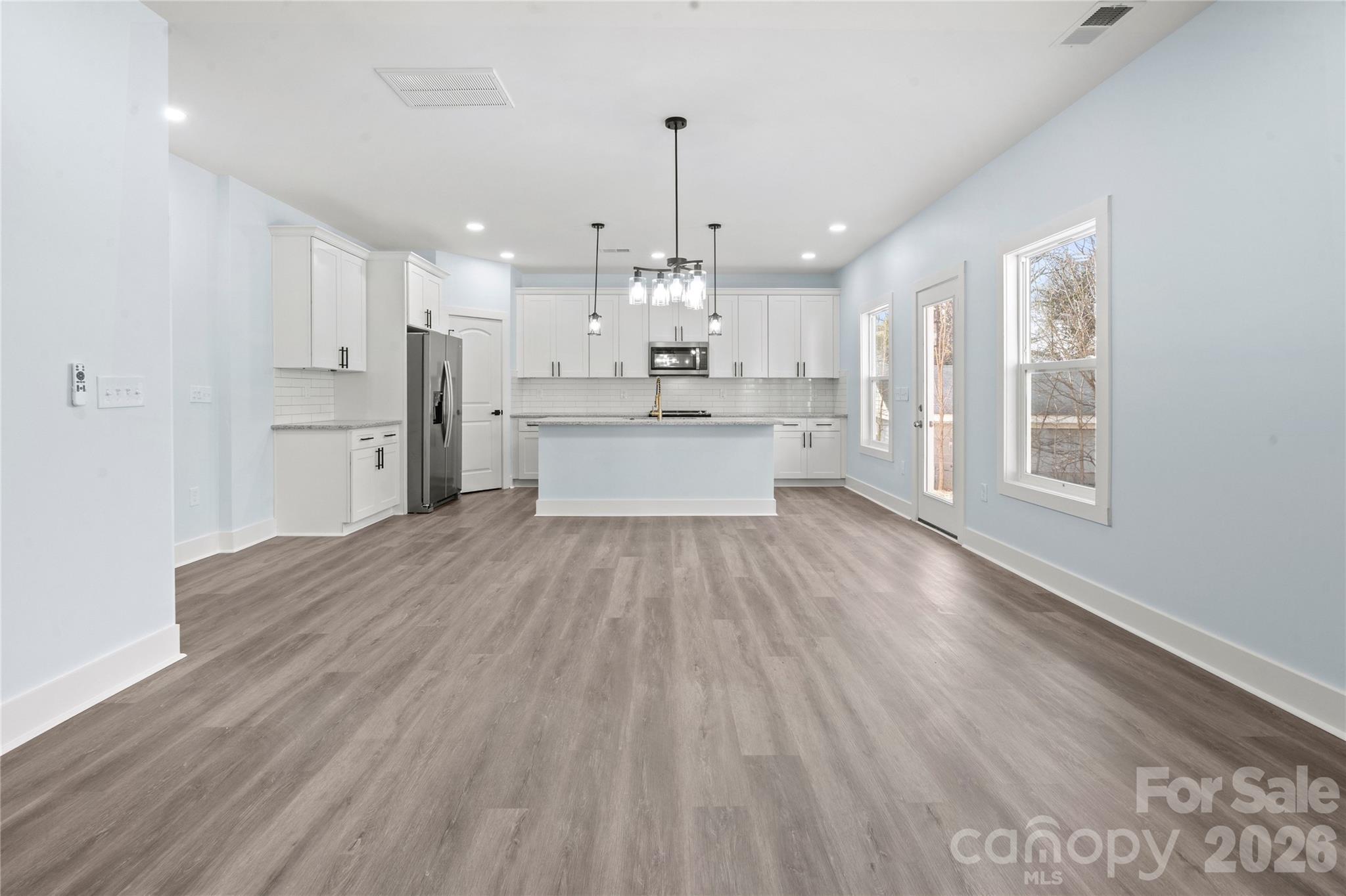 4524 Orphanage Road Concord, NC 28027 - Photo 17 of 29 a large kitchen with cabinets wooden floor and stainless steel appliances
