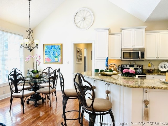 512 Maple Leaf Way Lumberton, NC 28358 - Photo 16 of 27 a view of a dining room with furniture a kitchen and a chandelier