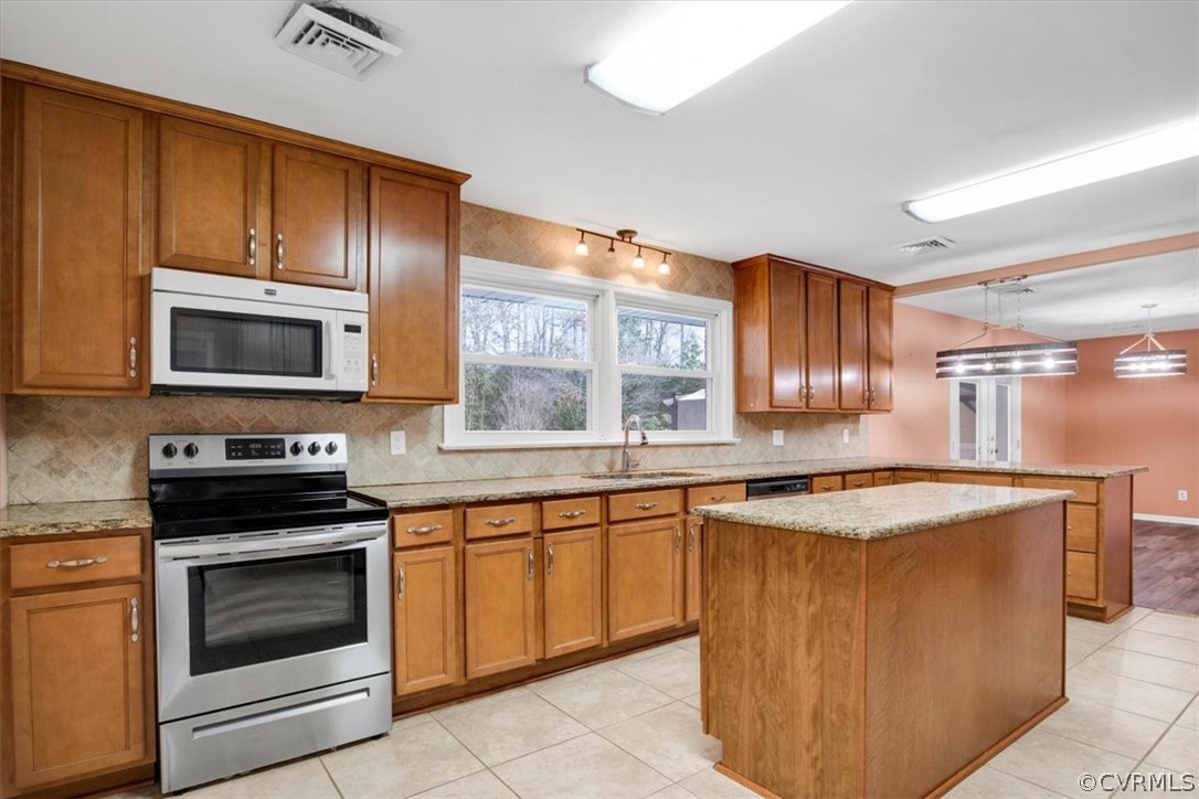a kitchen with stainless steel appliances granite countertop a stove top oven a sink dishwasher and a microwave oven on the blue kitchen countertops