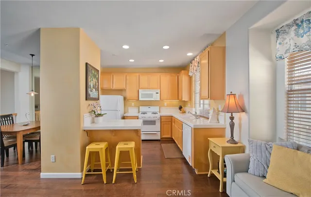 a living room with stainless steel appliances kitchen island granite countertop furniture and a large window