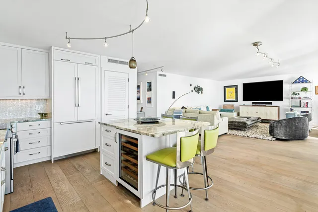 a view of a hallway with wooden floor and a living room