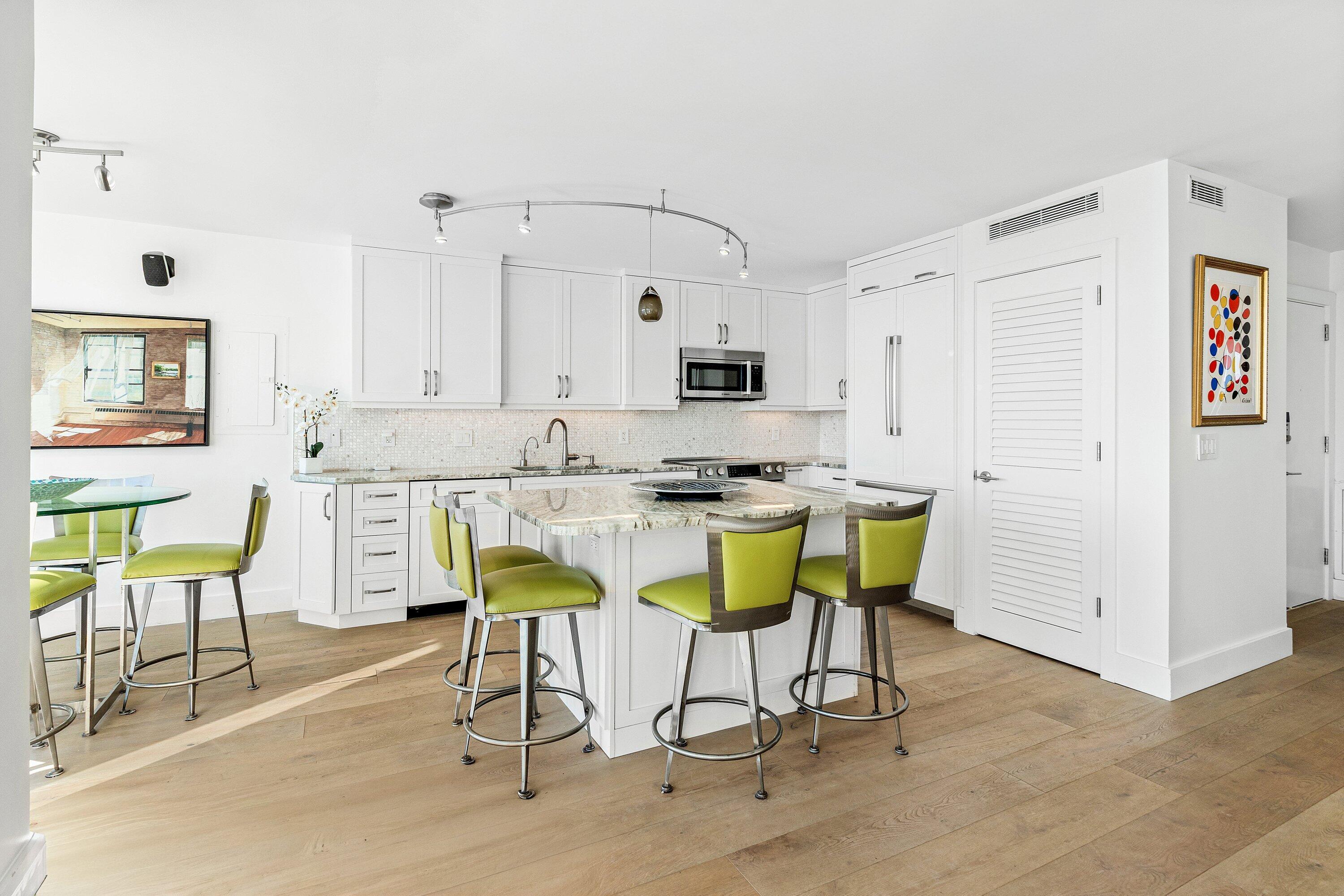 2800 South Ocean Boulevard, Unit LPHC Boca Raton, FL 33432 - Photo 9 of 39 a kitchen with stainless steel appliances kitchen island granite countertop a table chairs and a refrigerator