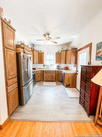 a large kitchen with stainless steel appliances granite countertop a refrigerator and a stove top oven