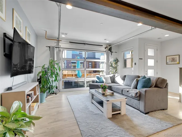 a living room with furniture a flat screen tv and a large window