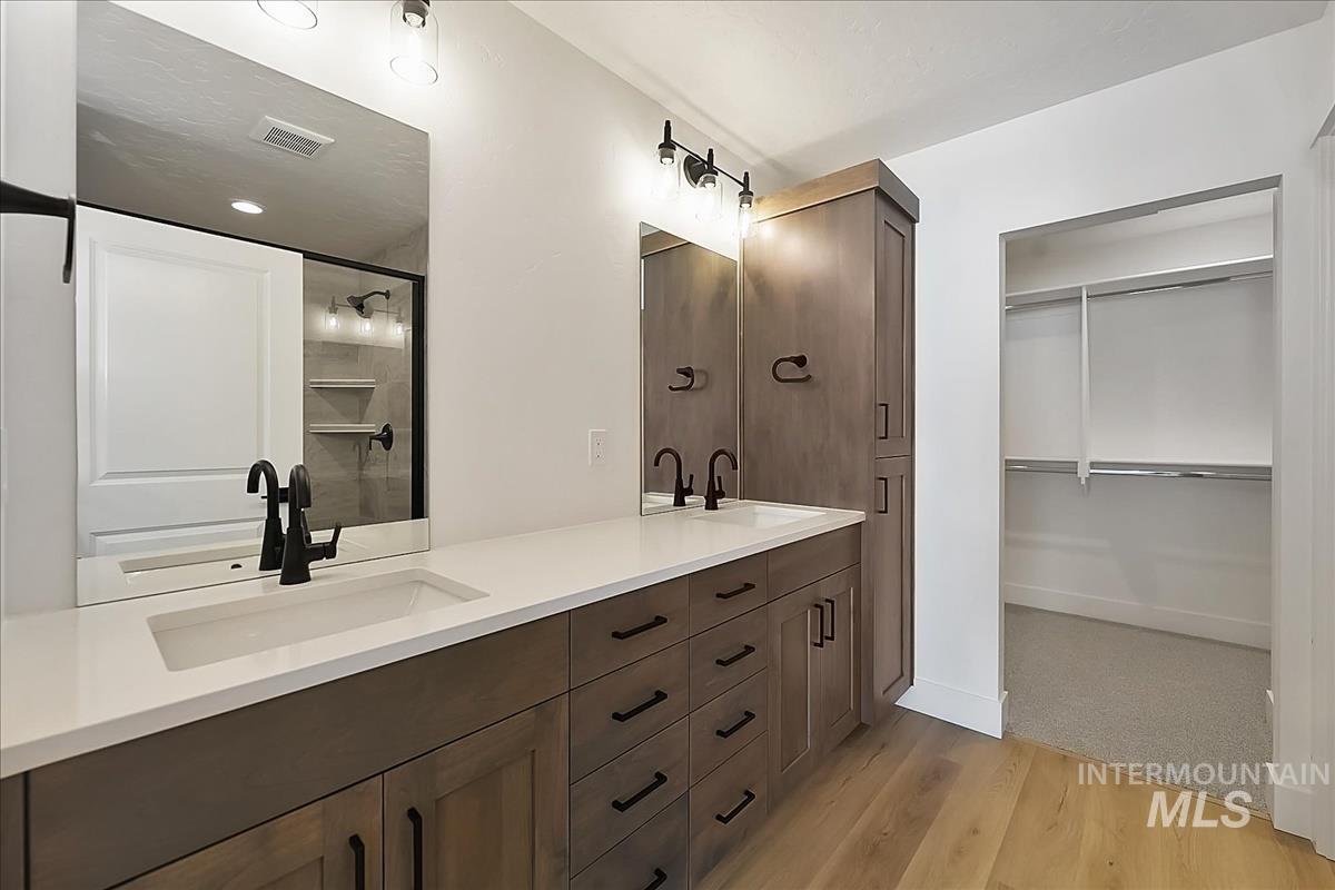 776 South Calhoun Lane Star, ID 83669 - Photo 28 of 49 Double vanity with undermount sinks, white countertops, and dark wood-finish cabinetry
