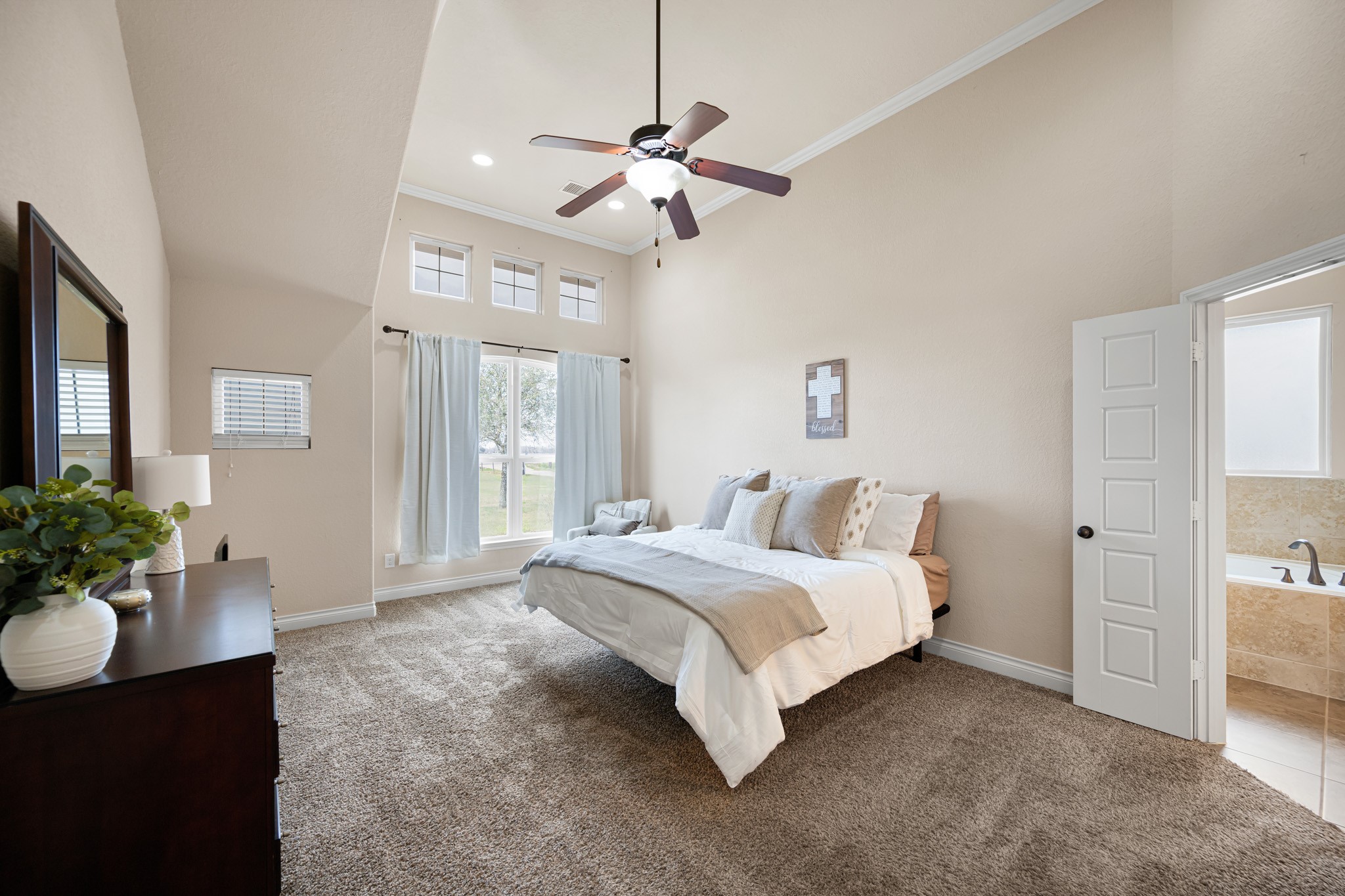 8131 Brinkmeyer Road Needville, TX 77461 - Photo 18 of 34 Primary bedroom with a high vaulted ceiling and abundant natural light from the large windows.