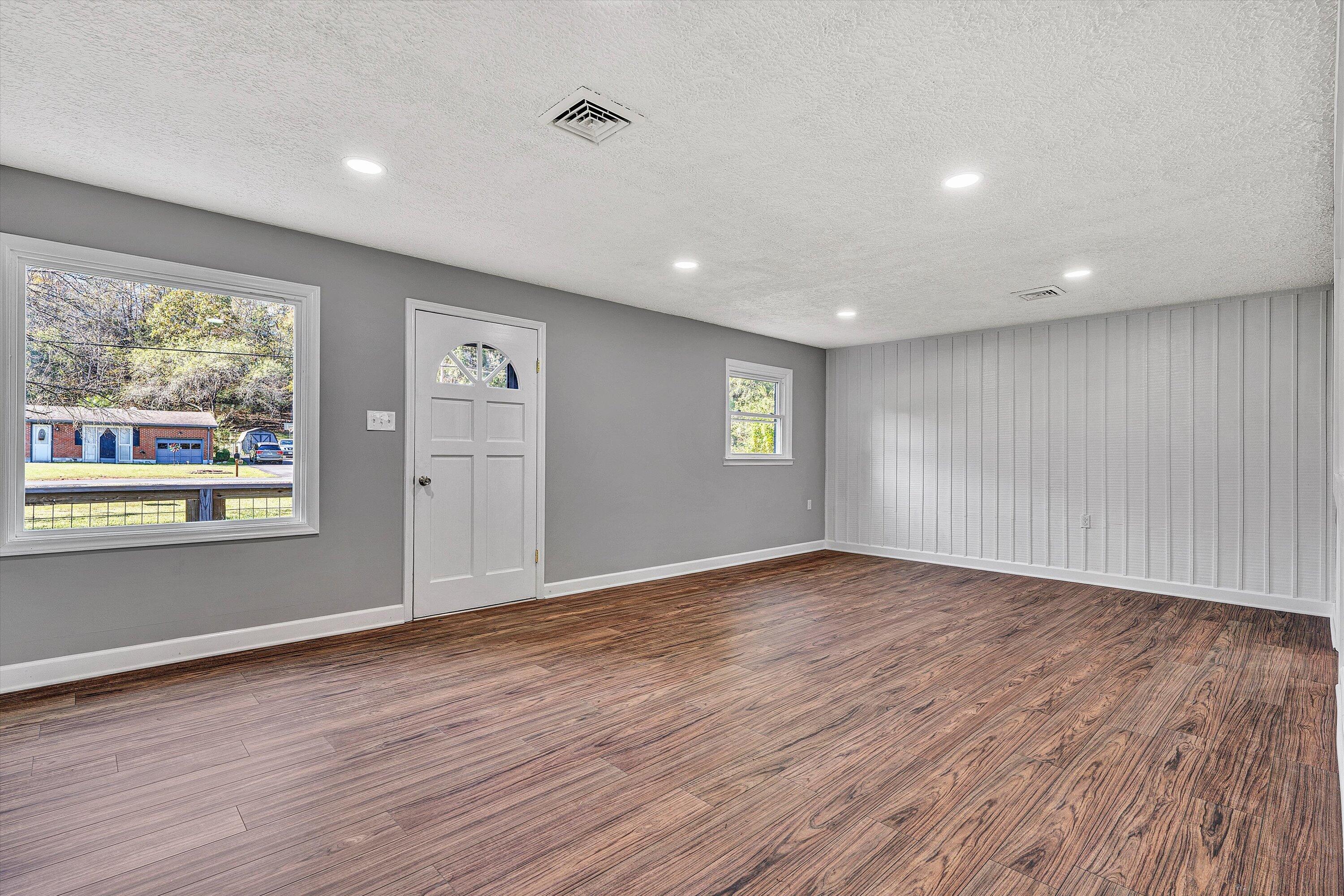 304 Broken Arrow Lane Covington, VA 24426 - Photo 13 of 46 an empty room with wooden floor and windows