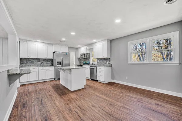 a kitchen with a white cabinets stove top oven and refrigerator
