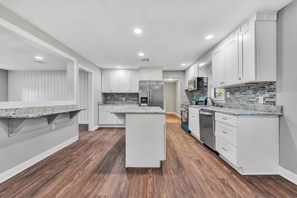 a kitchen with stainless steel appliances granite countertop a refrigerator and a stove