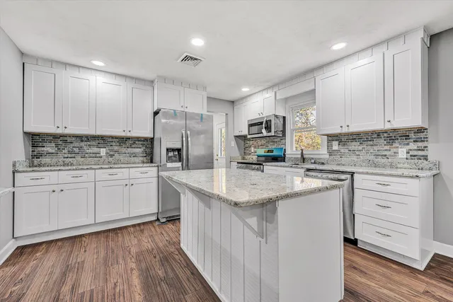 a kitchen with stainless steel appliances granite countertop a sink stove and refrigerator