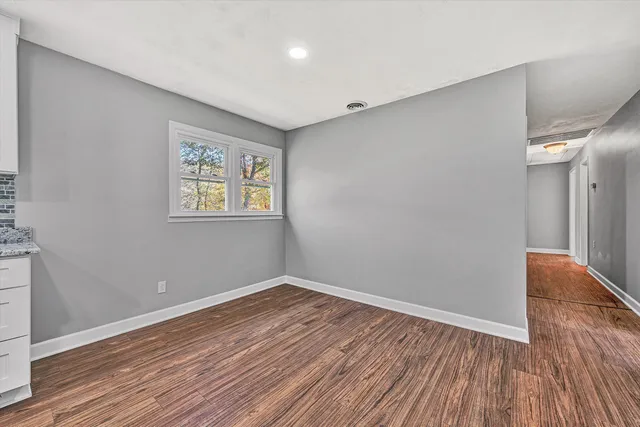 a view of empty room with wooden floor
