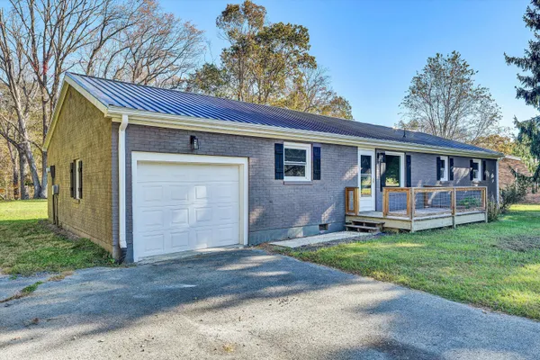a view of a house with a yard and sitting area