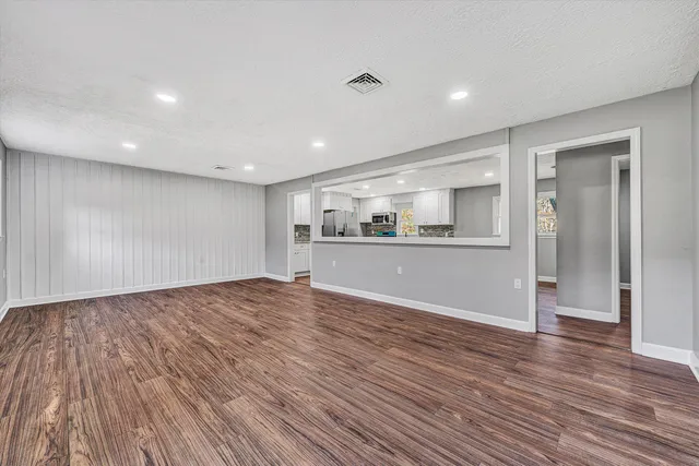 a view of empty room with wooden floor