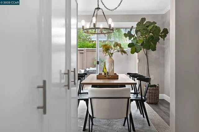 a view of a dining room with furniture a potted plant and a chandelier