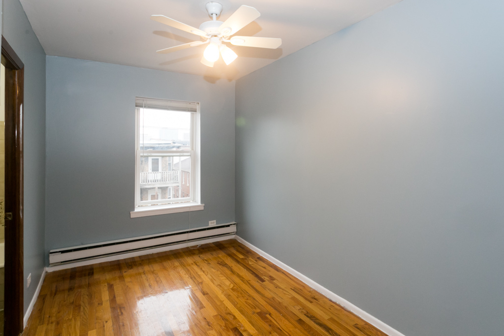 4515 North Malden Street, Unit 3C Chicago, IL 60640 - Photo 12 of 18 an empty room with a window and ceiling fan