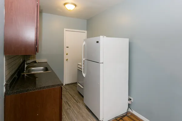 a white refrigerator freezer and a stove sitting inside of a kitchen