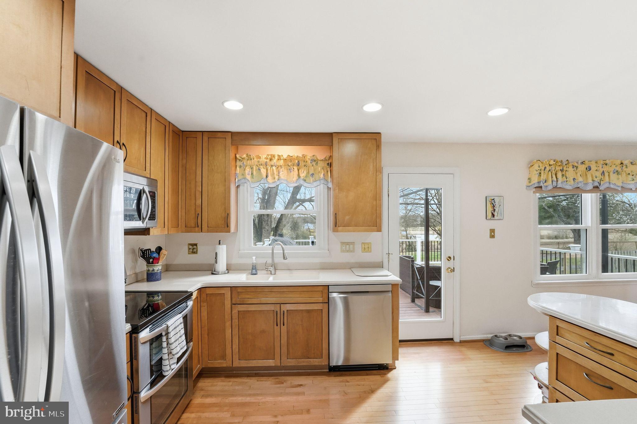 4051 Ringwood Road Nokesville, VA 20181 - Photo 19 of 58 a kitchen with stainless steel appliances granite countertop a refrigerator a sink a stove and white cabinets with wooden floor