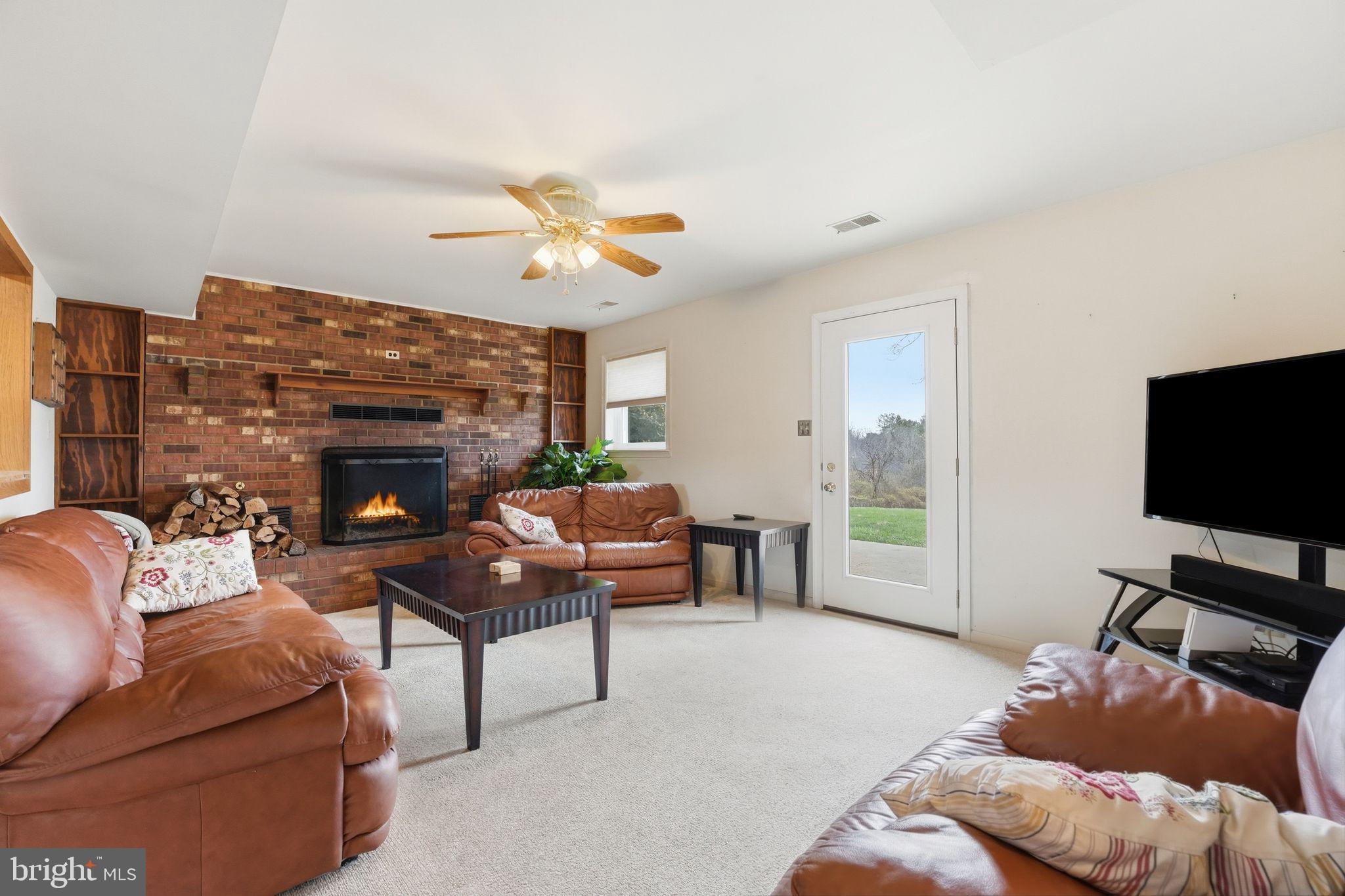 4051 Ringwood Road Nokesville, VA 20181 - Photo 34 of 58 a living room with furniture a fireplace and a flat screen tv
