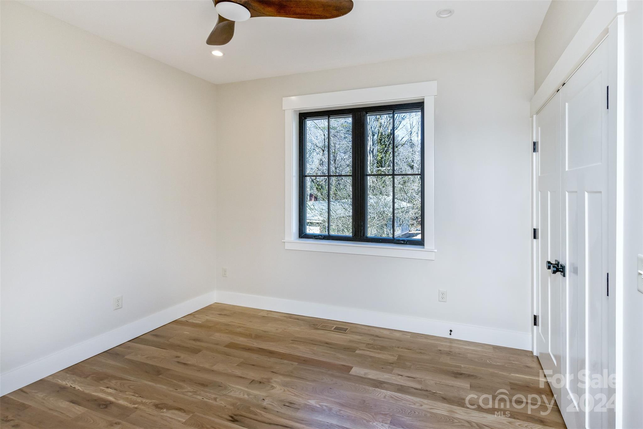 157 Gashes Creek Road Asheville, NC 28805 - Photo 28 of 43 an empty room with wooden floor and windows