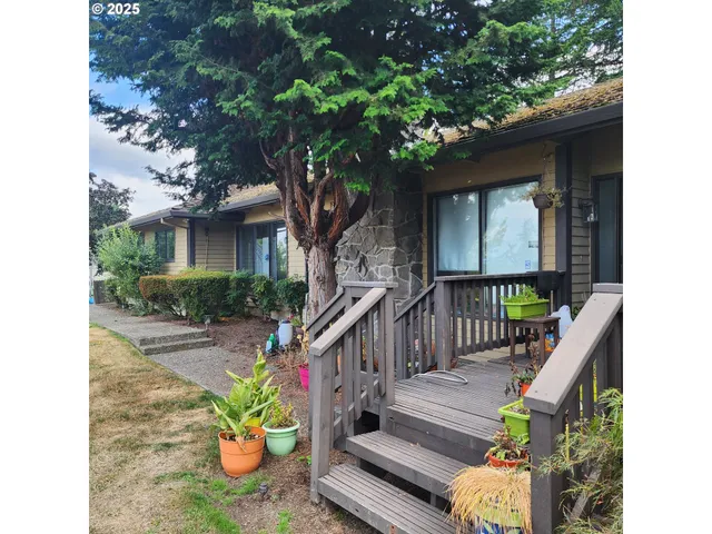 a view of a house with wooden stairs and a small yard