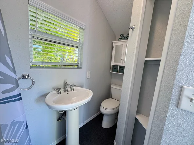 a bathroom with a sink toilet and a mirror