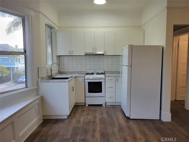 a kitchen with a refrigerator sink and cabinets