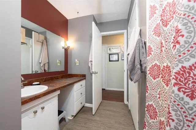 a spacious bathroom with a granite countertop sink and a mirror