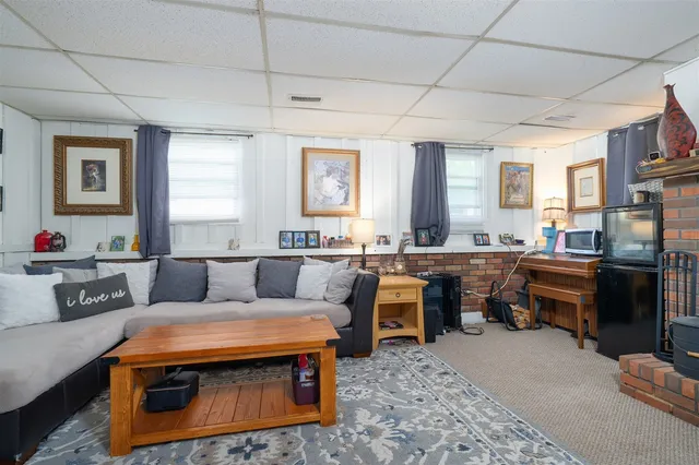a living room with furniture and a kitchen appliance view