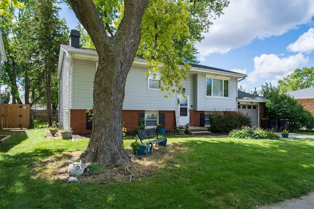 a front view of a house with a yard and trees