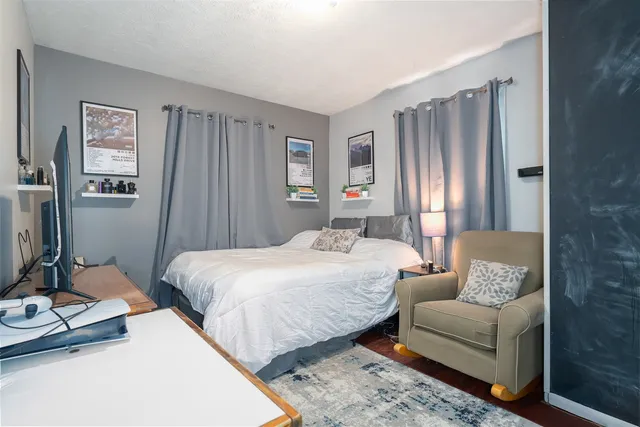 a bedroom with a bed couch and a window