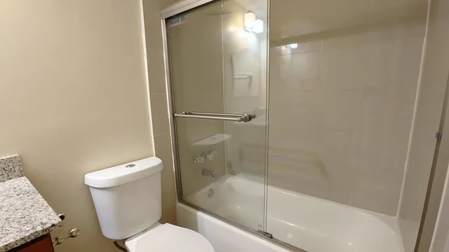 a bathroom with a granite countertop toilet a sink and bathtub