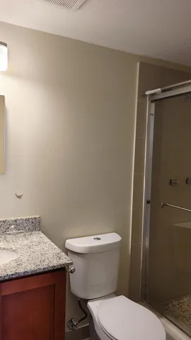 a bathroom with a granite countertop toilet and a sink