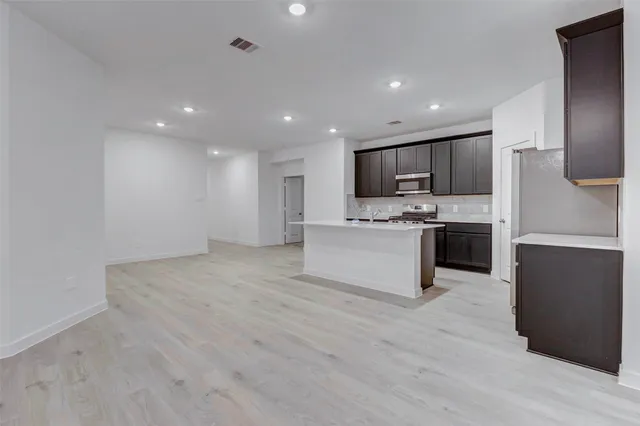 a large kitchen with a center island and stainless steel appliances