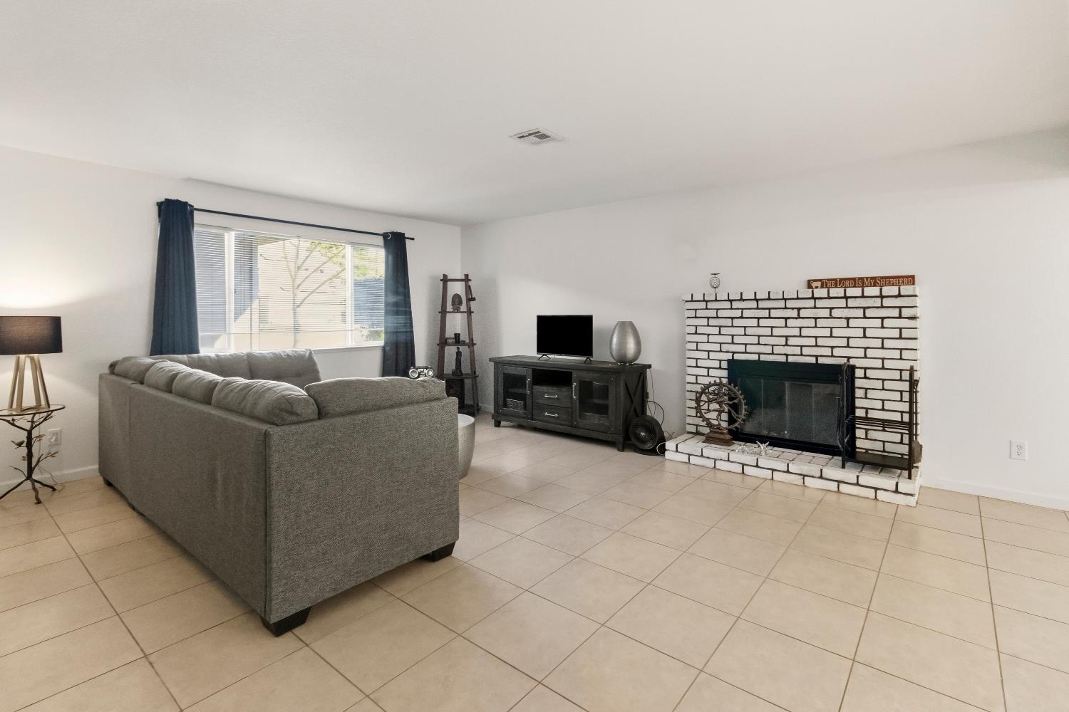 7428 Ranch Avenue Citrus Heights, CA 95610 - Photo 12 of 49 a living room with furniture a fireplace and a flat screen tv