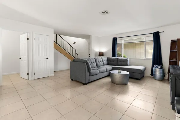 a living room with furniture a flat screen tv and a large window