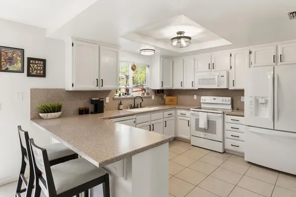 a kitchen with white cabinets and stainless steel appliances