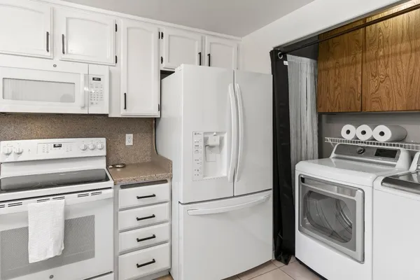 a kitchen with cabinets stainless steel appliances and a refrigerator