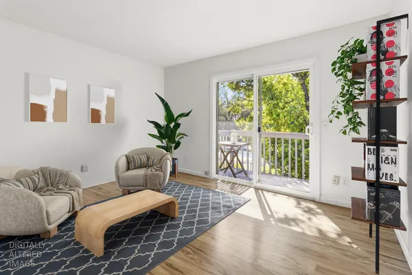 a living room with furniture floor to ceiling window and a flat screen tv