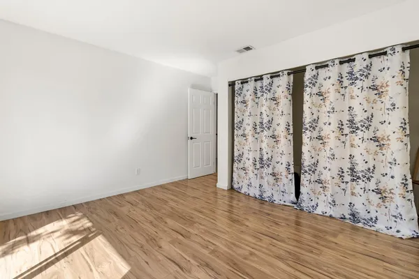 a view of a bedroom with wooden floor and bathroom