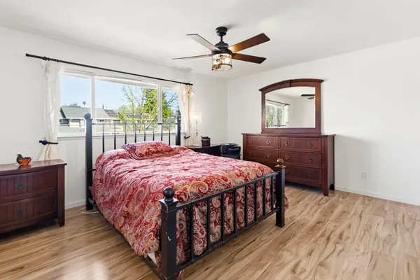 a bedroom with a bed and a dresser next to a window