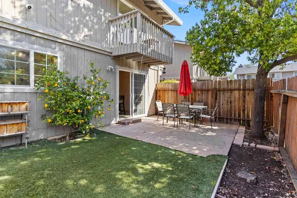 a view of a chair and table in backyard of the house