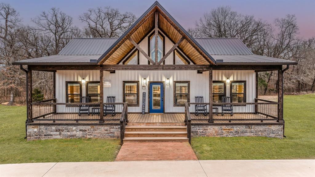 239 32507th Road Paris, TX 75460 - Photo 8 of 40 View of front of house featuring covered porch, a metal roof, a front lawn, and board and batten siding
