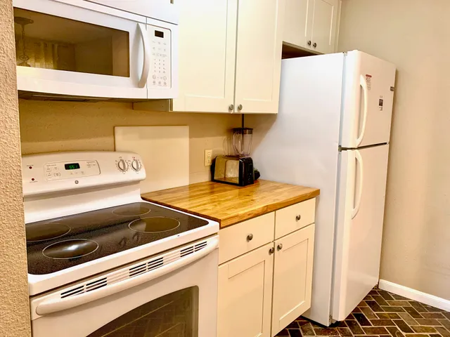 a kitchen with a refrigerator and a stove